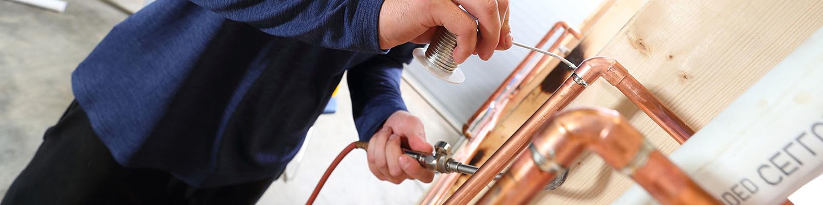 student sodering copper pipe